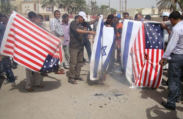 Iraquianos simpatizantes do movimento do cl�rigo xiita, Moqtada al-Sadrs, queimaram bandeiras dos EUA e de Israel como forma de protesto - AFP PHOTO/ALI AL-ALAK