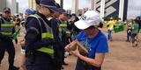 Manifestantes são revistados na entrada do protesto, na Biblioteca Nacional. Policiais olham se eles têm garrafas de vidro, material cortante, pedaços de madeira, máscara e mastro