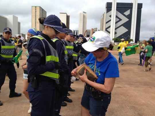 Manifestantes são revistados na entrada do protesto, na Biblioteca Nacional. Policiais olham se eles têm garrafas de vidro, material cortante, pedaços de madeira, máscara e mastro