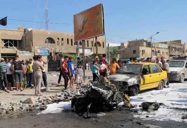Moradores se reúnem no local de um ataque com carro-bomba em Hurriya Distrito de Bagdá (Stringer/Iraq)