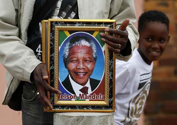 Um vendedor ambulante vende retratos de Nelson Mandela em Vilakazi Street, em Soweto (Yves Herman/ REUTERS)