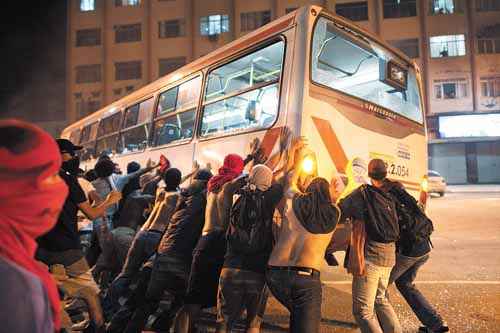Mascarados participam de depredação de ônibus em Niterói, em junho de 2013: projeto abre brecha para punir manifestantes como terroristas (Christophen Simon/AFP - 19/6/13)