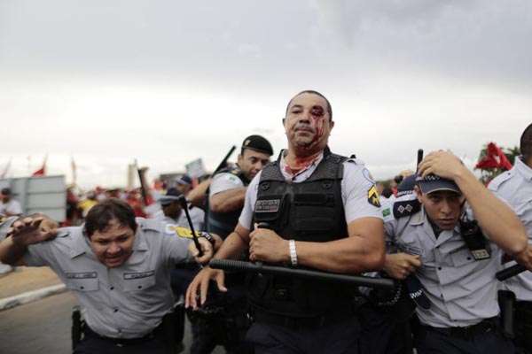 Policiais se protegem de objetos atirados por manifestantes na Praça dos Três Poderes: 30 PMs feridos (Ueslei Marcelino/Reuters - 12/2/14)