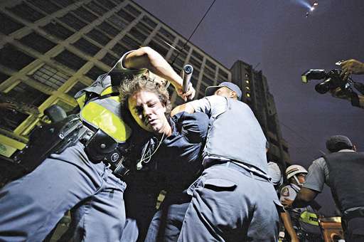 Policiais imobilizam manifestante durante protesto contra a Copa do Mundo: 262 ativistas detidos em São Paulo no último dia 22 (Nelson Almeida/AFP - 22/2/14)