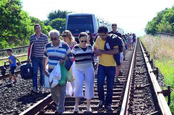 Passageiros andam pela linha férrea após problemas em trem próximo a Estação Park Shopping (Alex Rodrigues/Divulgação)