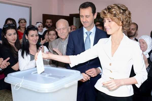 Presidente sírio Bashar al-Assad assiste a esposa votar nas eleições presidenciais na terça-feira. Os outros dois candidatos, desconhecidos, obtiveram 4,3% e 3,2% dos votos (Ho/Sana/AFP photo)