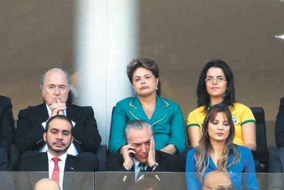 Sentada próximo ao presidente da Fifa, Joseph Blatter, que também foi xingado, Dilma evitou contato com a imprensa e os torcedores (William Volcov/Agência O Globo)