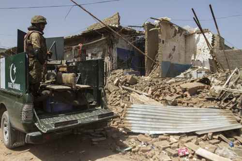 Soldados paquistaneses observam casas destruídas após ataque (Maqsood Mehdi/Reuters)