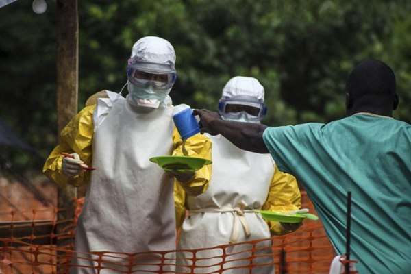 Equipe médica prepara-se para trazer comida para os pacientes mantidos em uma área de isolamento no centro de tratamento de ebola. Desde março, mais de 1.200 pessoas foram infectadas na África Ocidental, e mais de 800 morreram   (Tommy Trenchard/Reuters)