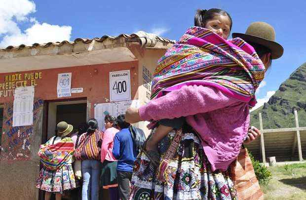 Mulher quechua carrega criança: trabalho em grupo é essencial para a sobrevivência da comunidade indígena peruana (Eric Danino/Reuters)