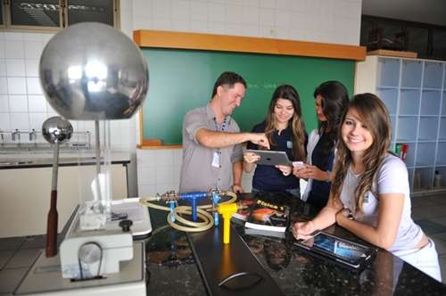 O professor de física Robert Cunha e as alunas Fernanda Queiroz, 17 anos, Fernanda Sindoval, 16, e Katherine Viana, 18, usam o tablet no laboratório de física