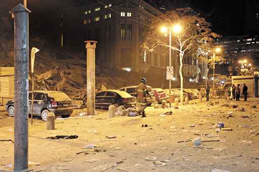 Bombeiro caminha em frente aos destroços: equipes de resgate buscam vítimas entre os escombros