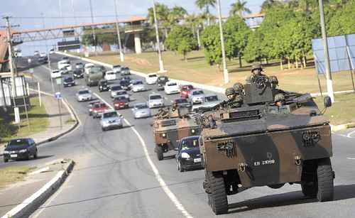 Veículos blindados do Exército em meio ao trânsito na avenida Paralela, que liga o aeroporto à região central de Salvador