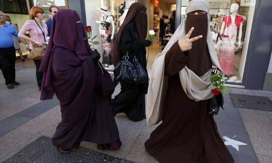 Três mulheres usando nicabes caminham por Cannes. A França proibiu o uso de véus que cubram todo o rosto em 2011