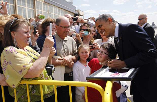 Obama assina um porta-retrato com uma foto dele na chegada a Minnesota