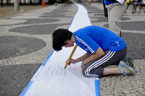 Pessoas que passam pela Praia de Copacabana deixam mensagens sobre os oceanos em uma folha de papel com 150 metros, o Poema Gigante. A iniciativa foi criada pelo artista Angel Arenas e já percorreu 45 cidades do mundo