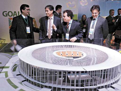 Maquete do Estádio Nacional é apresentada aos chilenos pelo presidente da Embratur, Flávio Dino (E)