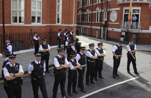 Policiais da Scotland Yard diante da embaixada, em Londres, enquanto Julian Assange (na sacada, D) discursava no domingo (19/8)