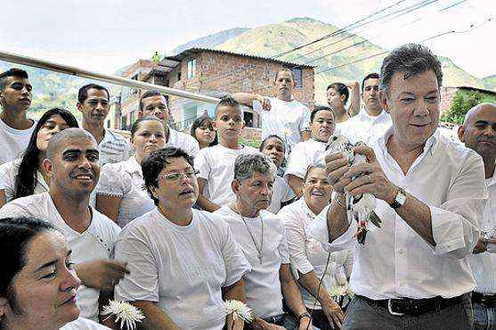 Juan Manuel Santos, com uma pomba, símbolo da paz, durante evento em Antióquia: presidente quer priorizar saída pacífica