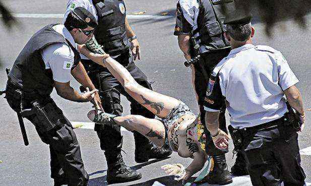 Com os seios à mostra, duas manifestantes do grupo Femen Brasil invadiram a parada. Elas foram retiradas por PMs e levadas à DP