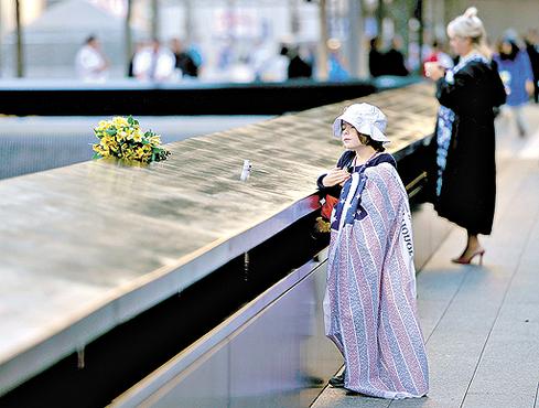 Ava Schmoelzer, de 7 anos, deposita flores no local da Torre Sul do World Trade Center, em memória à tia