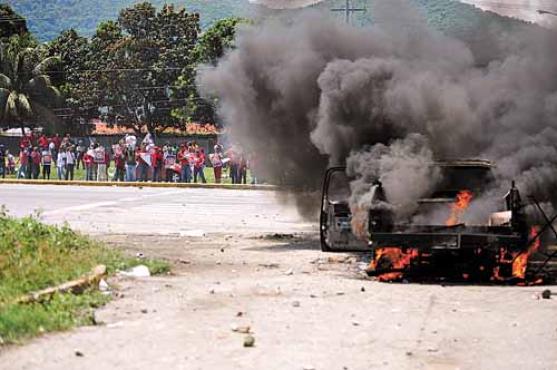 Veículo incendiado no embate entre partidários de Chávez e de Capriles