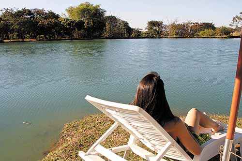 Com vista para um lago, a turista aproveita para descansar: tranquilidade no Villa Triacca