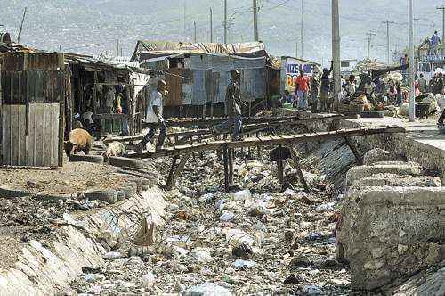 Lixo praticamente cobre leito de córrego em Porto Príncipe: infraestrutura precária expõe os moradores das favelas ao risco do contágio da bactéria, que se prolifera por meio da água imunda