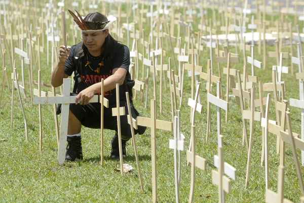 Elizeu Lopes Guarani- Kaiowá coloca cruzes, simbolizando os mortos