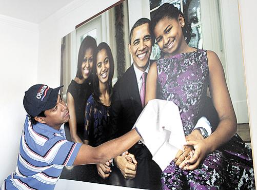 O advogado colombiano Silvio Carrasquilla, declarado fã de Obama, limpa o pôster de recente visita do presidente a Cartagena