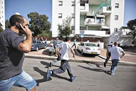 Israelenses correm em busca de proteção, durante ataque a Ashkelon