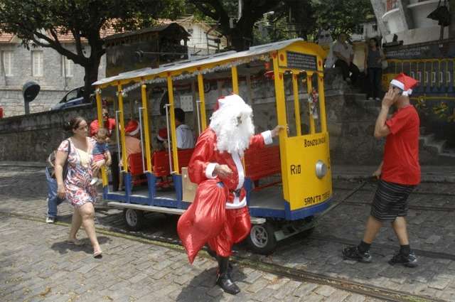 Homens transportam a réplica do bondinho de Santa Teresa criada pelo artista plástico Getulio Damado para manter a tradição de levar Papai Noel pelo bairro na proximidade do Natal