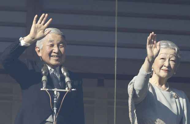 Imperador Akihito e a imperatriz Michiko acenam para as pessoas em aparição pública