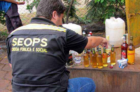 Agente da fiscalização apreendendo produtos em frente ao Estádio Nacional