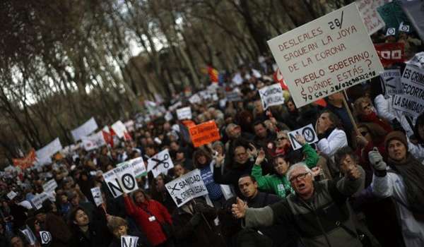 Vestidos com jalecos, médicos, enfermeiros e cidadãos protestam em Madri