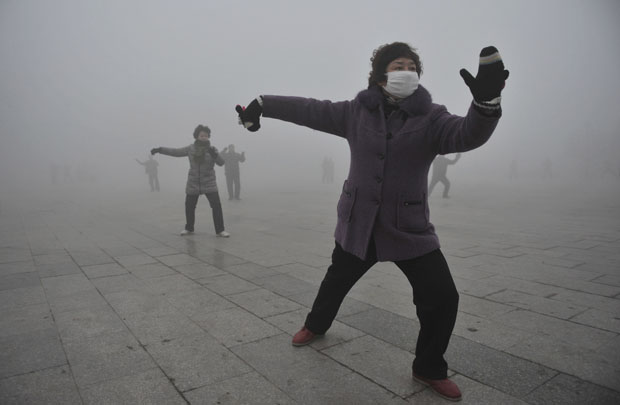 Mulher usa máscara durante exercício ao ar livre na manhã de ontem, em Fuyang, província de Anhu. A vigilância ambiental da China ordenou grandes esforços para emitir alertas para poluição do ar, que atingiu diversas partes do país nos últimos dias