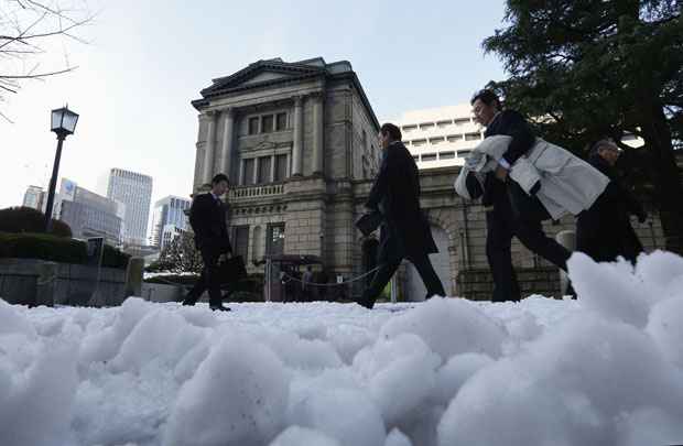 Japoneses passam por rua coberta de neve em frente ao Banco do Japão