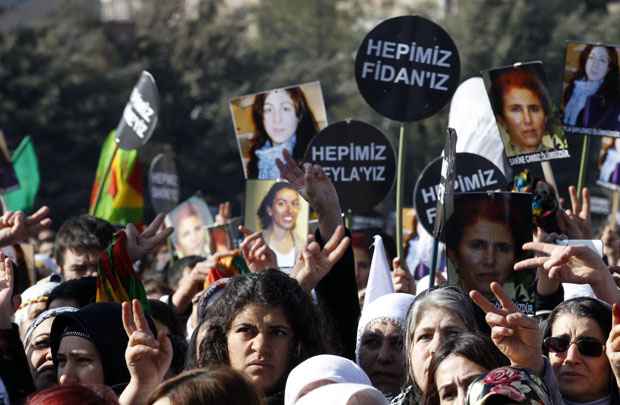 Manifestantes seguram cartazes com imagens das vítimas durante protesto