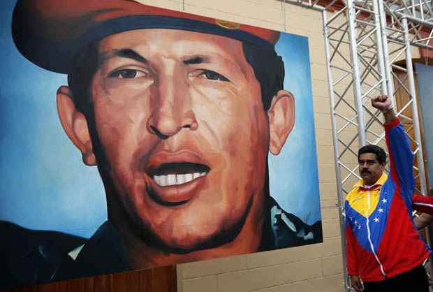 Maduro ao lado de mural com pintura do rosto do presidente