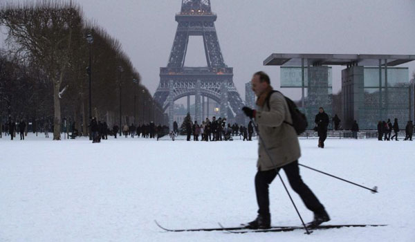 Por conta da grande quantidade de neve, homem esquia próximo à Torre Eiffel