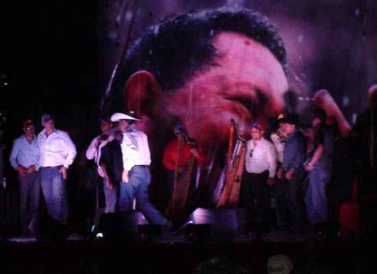 Em homenagem ao presidente, grupo toca músicas tradicionais em palco montado a cerca de 1km do local onde o corpo de Chávez é velado