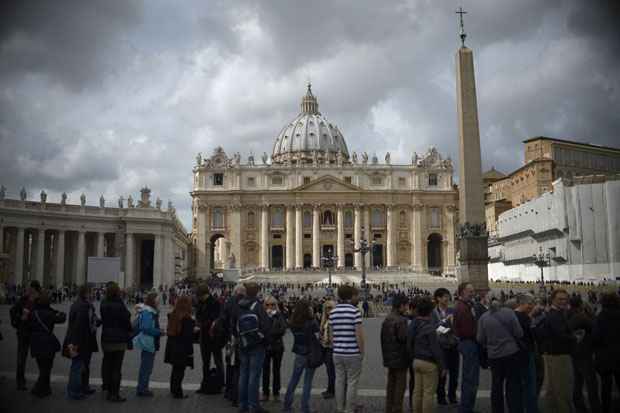 Turistas fazem fila para entrar na Basílica de São Pedro, na praça de São Pedro, depois de uma reunião de cardeais na véspera do início de um conclave