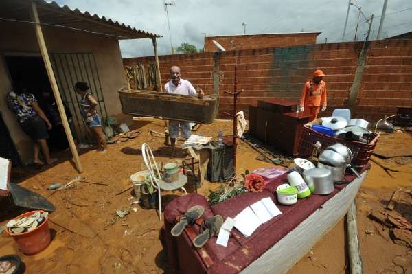 Família tenta salvar alguns dos pertences depois da casa ser invadida pela água