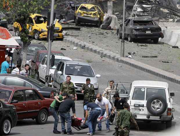 Voluntários carregam vítima de explosão de carro-bomba que abalou centro de Damasco