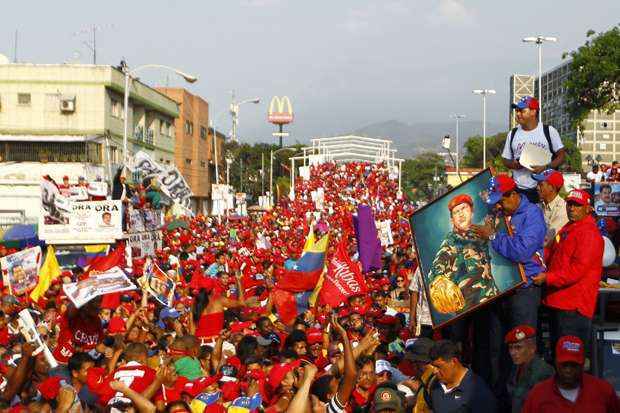 Presidente em exercício da Venezuela e candidato presidencial, Nicolas Maduro (D, em azul) durante comício de campanha no estado de Vargas