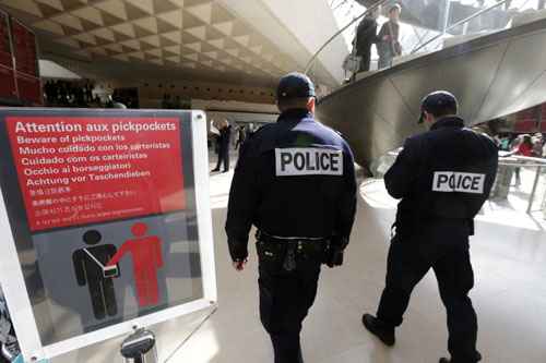 Polícia francesa caminha em uma das entradas do museu do Louvre passando sinal de alerta contra carteiristas 
REUTERS / Philippe Wojazer