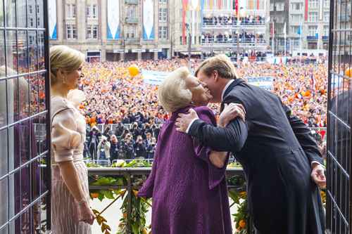 A rainha Beatrix beija o filho, Willem-Alexander, sob os olhares da nova rainha-consorte, a argentina Máxima Zorraguieta, e em meio à aclamação dos súditos em Amsterdã