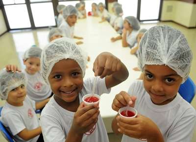 Gabriel e Yasmin, ambos de 5 anos, preparam gelatina para o lanche da turma nas aulas do projeto Cozinha pedagógica