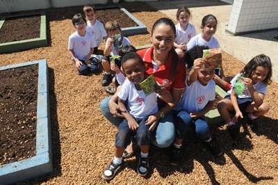 A professora Alexandra Caetano e os alunos cultivam uma horta na escola