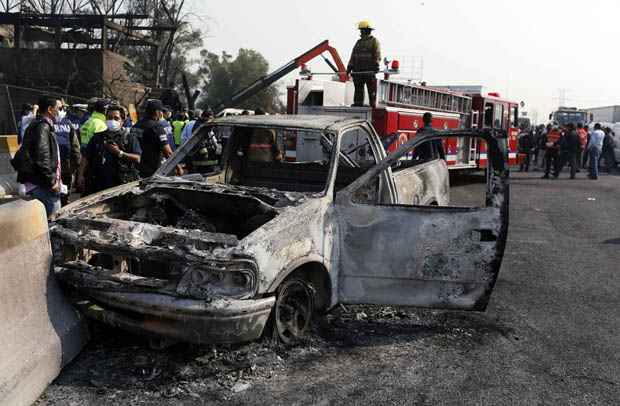 Policiais ao lado de caminhonete danificada pela explosão de caminhão-tanque em San Pedro Xalostoc, nos arredores da Cidade do México